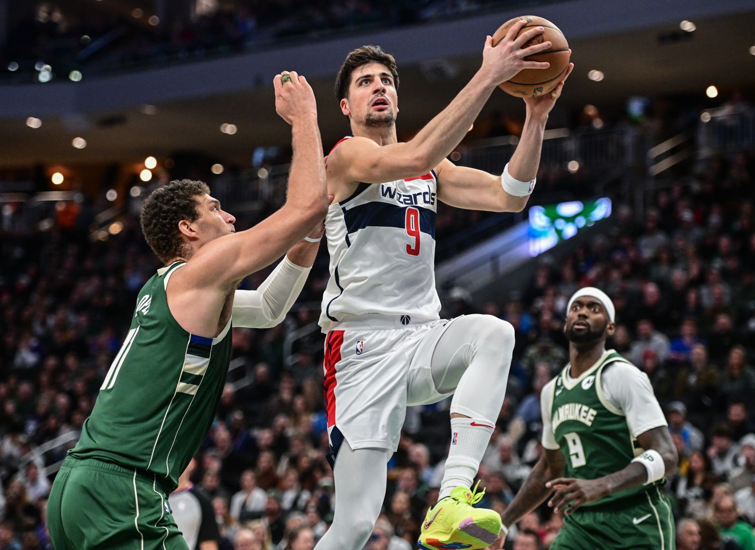 Washington Wizards forward Deni Avdija (9) takes a shot between Milwaukee Bucks center Brook Lopez (11) and forward Bobby Portis (9) at Fiserv Forum.